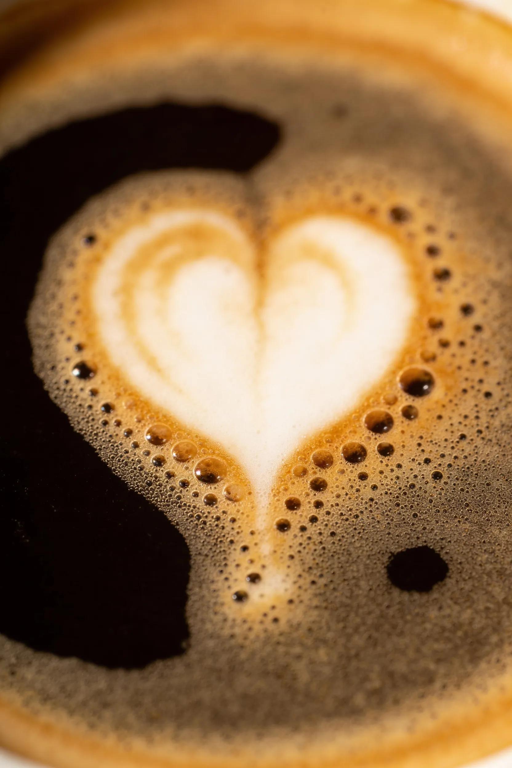 Latte art heart design on espresso showcasing creamy microfoam texture